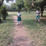 Students relaxing on the green school compound at Muhokya Parents Secondary School in Kasese.