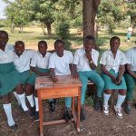 Students outside classroom buildings at Muhokya Parents Secondary School in Kasese District, Uganda.