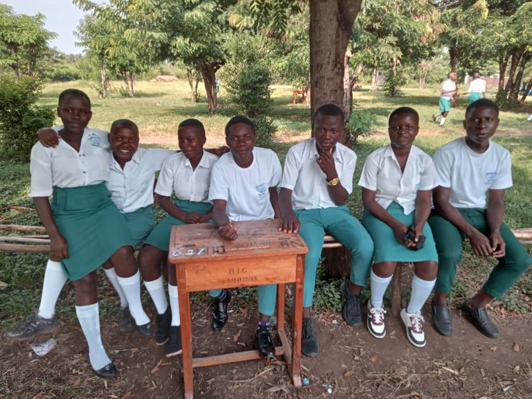 Students outside classroom buildings at Muhokya Parents Secondary School in Kasese District, Uganda.